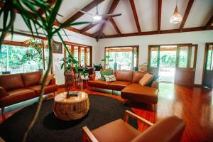 un soggiorno con divani in pelle e tavolo di Paperbark Retreat a Cooktown