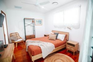 a bedroom with a large bed and a chair at Paperbark Retreat in Cooktown