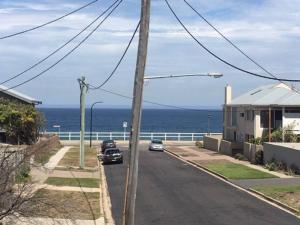 a street with a view of the ocean at Beach Retreat in Merewether +6 photos