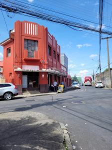 ein rotes Gebäude an der Ecke einer Straße in der Unterkunft Kitnet BH in Belo Horizonte