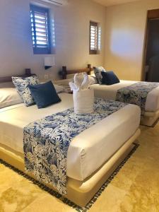 a bedroom with two beds with blue and white sheets at Stunning beachfront house w/ private pool. in Zihuatanejo