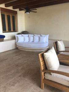 a living room with white pillows on a couch at Stunning beachfront house w/ private pool. in Zihuatanejo