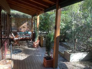 a porch of a house with a swing at Real Romance Cottage in Hanmer Springs +8 photos