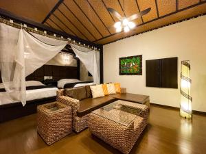 a living room with a couch and a bed at Hotel Asian Resort in Kōtōdaitōri