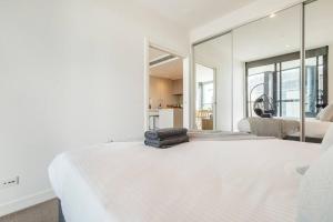 - une chambre avec un grand lit blanc et une grande fenêtre dans l'établissement Lovely 1 bedroom with free parking on premises - 00209, à Melbourne
