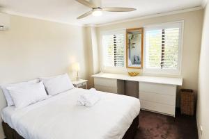 Un dormitorio blanco con una cama blanca y una ventana en Impressive Centrally Located Penthouse, en Sídney