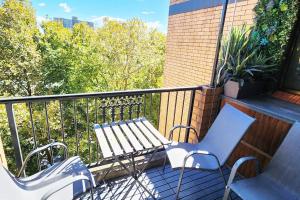 - une terrasse couverte avec un banc et 2 chaises sur un balcon dans l'établissement Impressive Centrally Located Penthouse, à Sydney