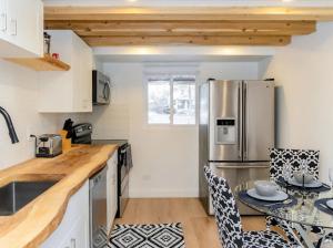 a kitchen with a stainless steel refrigerator and a table at Cozy Cottage Style House in Kitchener