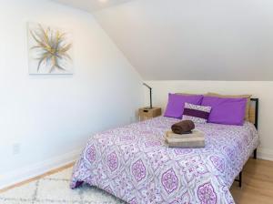 a bedroom with a purple bed with purple pillows at Cozy Cottage Style House in Kitchener