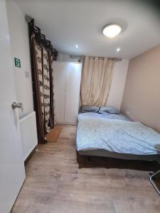 a bedroom with a bed in the corner of a room at Amazing 1 bed flat near Heathrow in Feltham