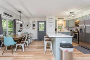 a kitchen with a table and chairs and a kitchen with a table and a counter at In The Woods - 5 BR Chalet with Game Room, Fire Table and Hot Tub in McGaheysville