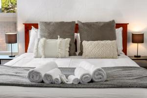 uma cama com toalhas e almofadas em Spectacular Views - One Bedroom Unit - Free Parking - Free WIFI em Sandy Bay