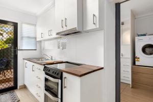 uma cozinha branca com um lavatório e um fogão em Spectacular Views - One Bedroom Unit - Free Parking - Free WIFI em Sandy Bay