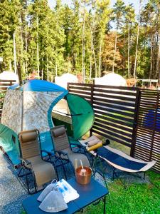 富士河口湖的住宿－HOSHIFULL DOME FUJI，院子里的一组椅子和帐篷