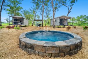 una piscina circolare in un cortile con una casetta di Litchfield Tropical Stay a Batchelor