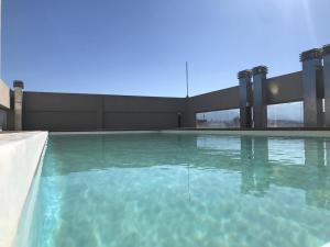 a swimming pool with blue water in a building at AIRES VERDES PREMIUM in Salta