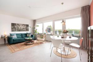 a living room with a green couch and a table at Strandbungalow Ostsee in Rettin