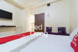 a room with a bed and a tv on a wall at Apartemen Kemang View - Room 88 Tower Acasia in Jakarta +11 photos