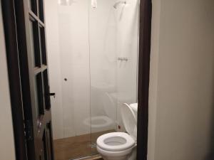 a bathroom with a toilet and a glass shower at Ajayu Sucre in Sucre