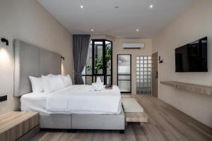 a bedroom with a white bed and a television at Muntri Maison in George Town