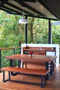 a picnic table and two benches on a deck at Sueño Río Celeste Boutique B&B in Bijagua