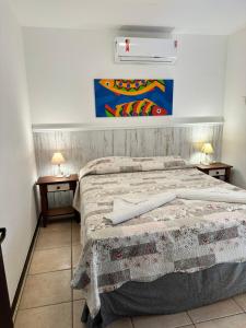 a bedroom with a bed with two night stands and two lamps at Pousada Pedra da Gaivota in Bombinhas