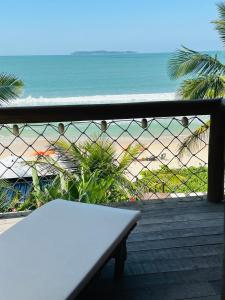 un banco sentado en una terraza con vistas a la playa en Pousada Pedra da Gaivota, en Bombinhas
