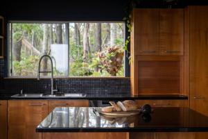 uma cozinha com um balcão com um lavatório e uma janela em Norm's Place + Waterfront House + Beachfront em Amity Point