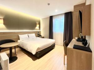 um quarto de hotel com uma cama e uma mesa em Hotel Foret The Spa em Busan