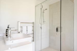 un bagno bianco con lavandino e doccia di Toad Hall - Cottage a Tintenbar Altre 18 foto