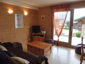 a living room with a couch and a table and a tv at Appartement Crest-Voland, 3 pièces, 4 personnes - FR-1-595-76 in Crest-Voland