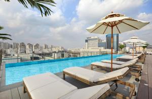 a swimming pool with lounge chairs and an umbrella at Somerset Central Bundang in Seongnam