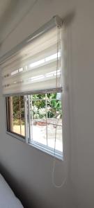 a window with a white blind in a room at Guest House Villa Hortensia in Santa Marta