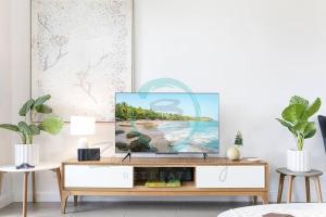 a living room with a tv on a dresser at ZEN NOMAD 2-BR Nightcliff Apt Near Markets & Shops in Nightcliff