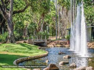 a fountain in a park with a pond and trees at ZEN NOMAD 2-BR Nightcliff Apt Near Markets & Shops in Nightcliff