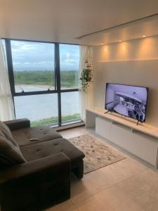 sala de estar con sofá y TV de pantalla plana en Barra Home Stay - Beira mar - 2 QUARTOS, en Recife