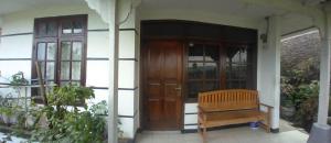 a wooden door and a bench in front of a building at Villa Galaxy Resort C15 in Cipanas