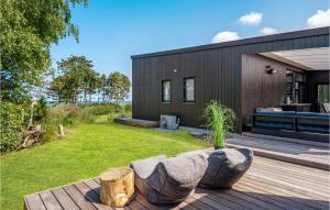 a backyard with a wooden deck and a house at Stunning Home In Kalundborg With House Sea View in Kalundborg
