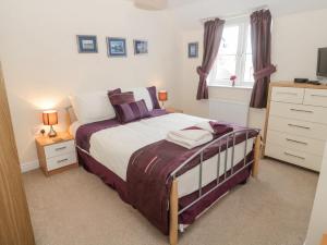 a bedroom with a bed and a dresser at Ramblers Cottage in Glanton
