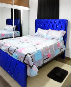 un letto blu con testiera blu in una camera da letto di las carreras centro D la ciudad a Santiago de los Caballeros