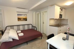 a small bedroom with a bed and a kitchen at Villa Pablo City Studios Koper in Koper +13 photos