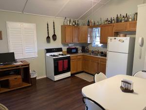a kitchen with a white refrigerator and a table at Lambert Park on Medina River in Bandera