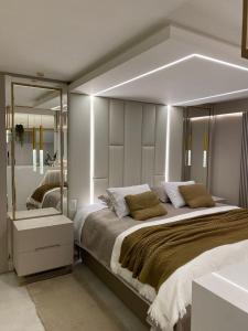 1 dormitorio con 1 cama grande y espejo grande en LOFT CENTRO GRAMADO, en Gramado