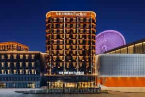 um edifício de hotel com uma roda gigante ao fundo em Fairfield by Marriott Chongqing Yongchuan em Chongqing