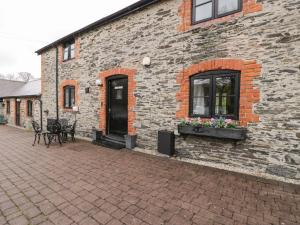 a brick building with a window and flowers on it at The Corn Store in Corwen