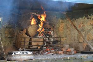 un fuego en un horno de ladrillo con llamas en Ivona - Kuća za odmor Perušić - Stara Lika, en Perušić