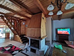 sala de estar con chimenea y TV en Dom leśny w Konarzynach en Stara Kiszewa
