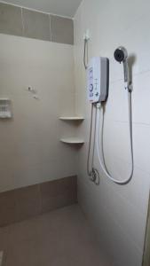 a shower in a bathroom with a phone on the wall at Gopeng Senada Holiday House in Gopeng