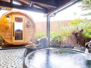 una vasca idromassaggio su un patio con sbarre di mare di 那古井館別邸　玉響[TAMAYURA] a Tamana