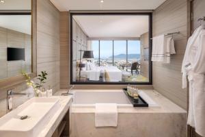 a bathroom with a tub and a large window at Melia Vinpearl Thanh Hoa in Thanh Hóa